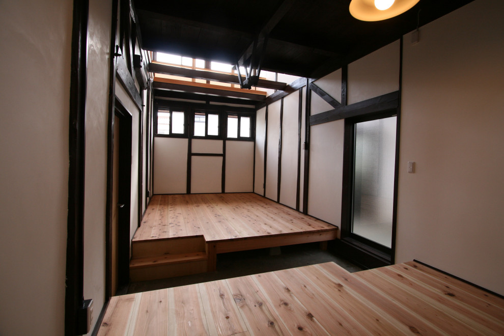 他の地域にあるお手頃価格の小さな和風のおしゃれな応接間 (白い壁、淡色無垢フローリング、暖炉なし、テレビなし、ベージュの床、表し梁、黒い天井) の写真