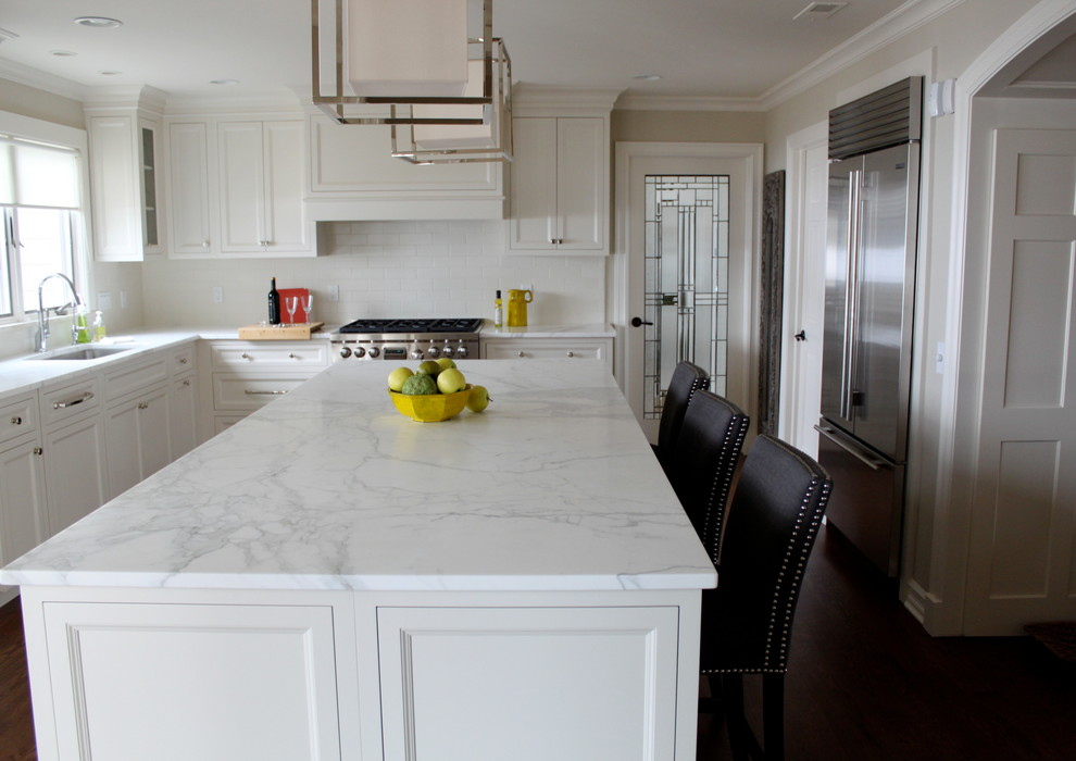 Inspiration for a large transitional l-shaped eat-in kitchen in Detroit with a single-bowl sink, white cabinets, white splashback, stainless steel appliances, with island, beaded inset cabinets, granite benchtops, subway tile splashback and medium hardwood floors.