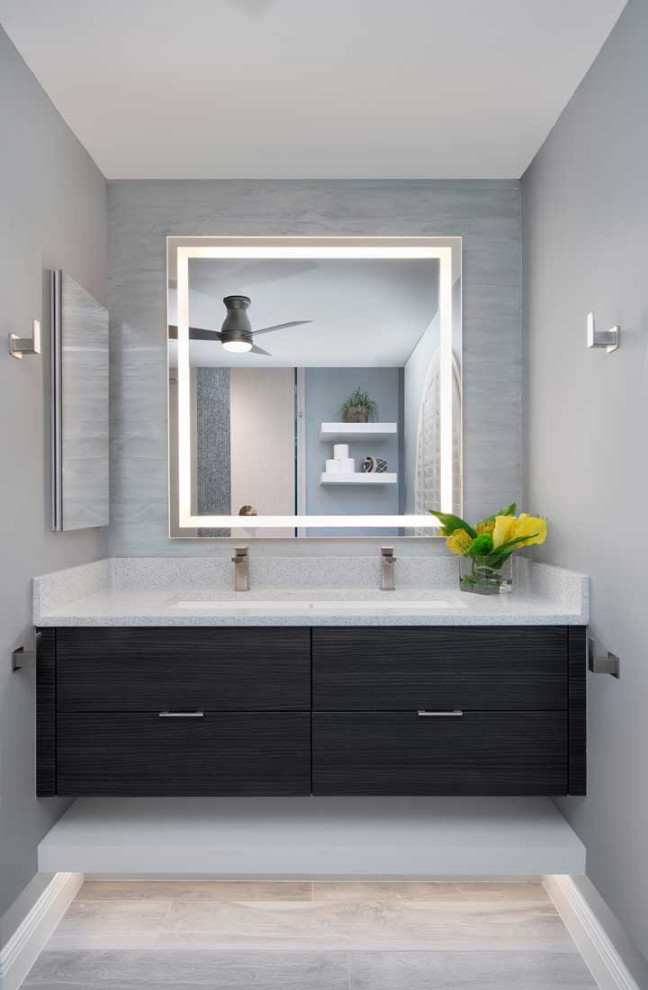 Photo of a medium sized contemporary shower room bathroom in Miami with flat-panel cabinets, dark wood cabinets, a corner shower, a two-piece toilet, multi-coloured tiles, porcelain tiles, blue walls, porcelain flooring, a submerged sink, engineered stone worktops, grey floors, an open shower, white worktops, a single sink, a floating vanity unit and a feature wall.