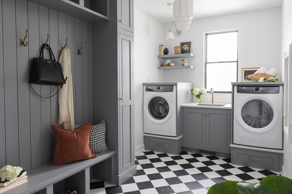 This is an example of a large transitional laundry room in Other with an undermount sink, grey cabinets, quartz benchtops, white splashback, engineered quartz splashback, white walls, porcelain floors, an integrated washer and dryer and white benchtop.