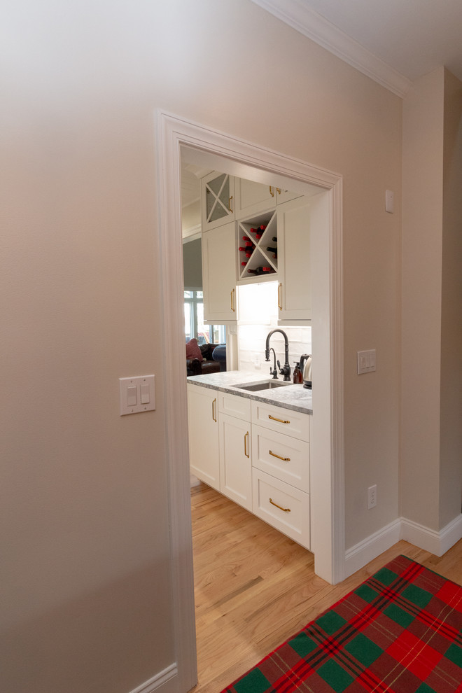 Example of a large l-shaped eat-in kitchen design with shaker cabinets, white cabinets, granite countertops, an island and white countertops