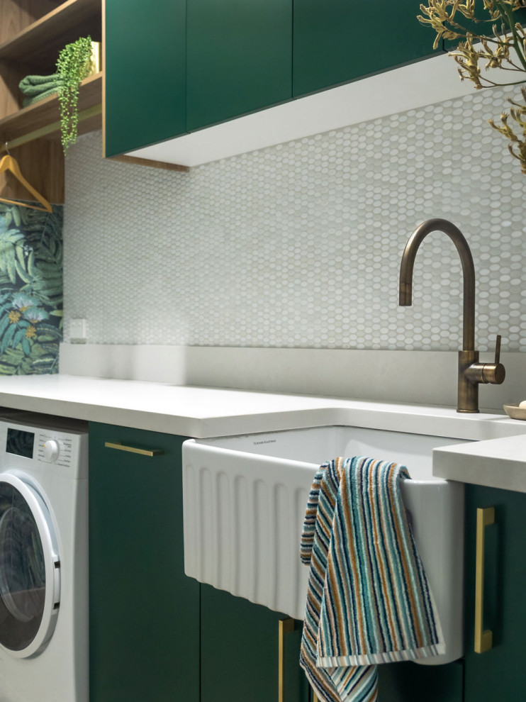 Inspiration for a mid-sized contemporary galley laundry room in Melbourne with a farmhouse sink, quartz benchtops, white splashback, ceramic splashback, green walls, porcelain floors, a side-by-side washer and dryer, white benchtop and wallpaper.