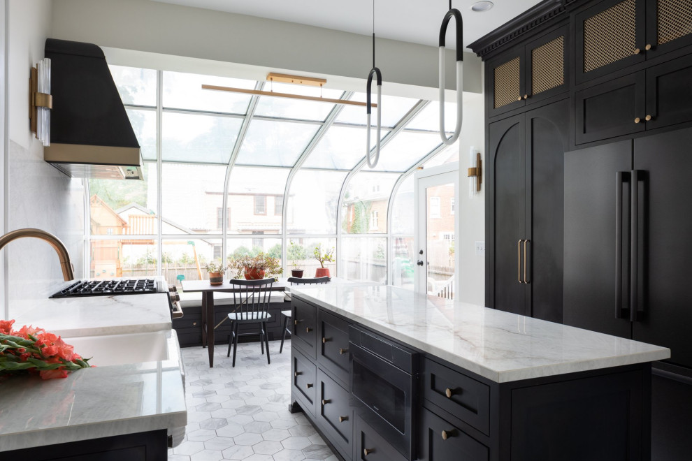 Inspiration for a transitional galley eat-in kitchen in Milwaukee with a farmhouse sink, shaker cabinets, brown cabinets, soapstone benchtops, beige splashback, stone slab splashback, black appliances, ceramic floors, with island, multi-coloured floor and beige benchtop.