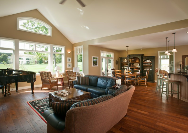 Design ideas for a mid-sized arts and crafts open concept family room in Other with a music area, beige walls, medium hardwood floors, a standard fireplace, a wood fireplace surround, a concealed tv and brown floor.