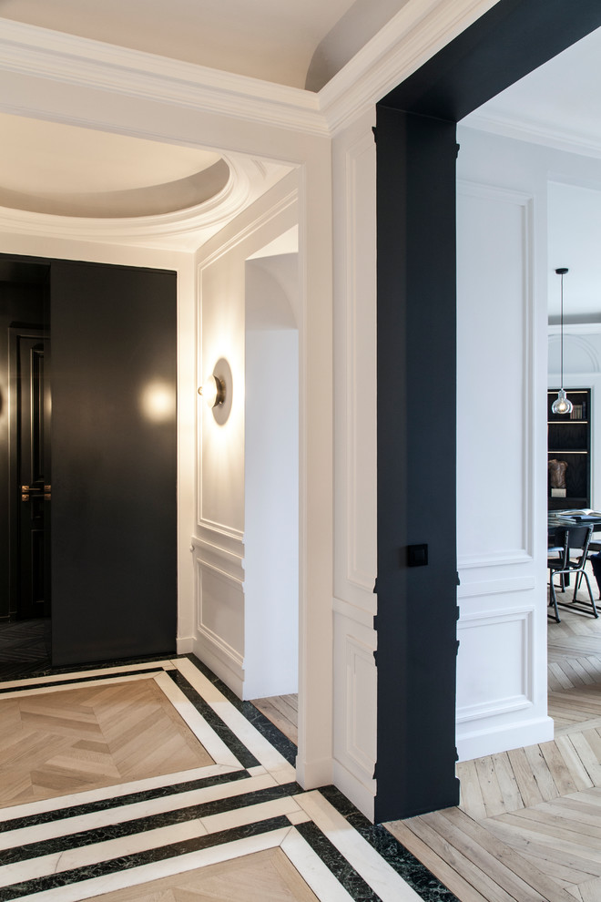 Large contemporary foyer in Paris with white walls, light hardwood floors, a double front door, a white front door and beige floor.