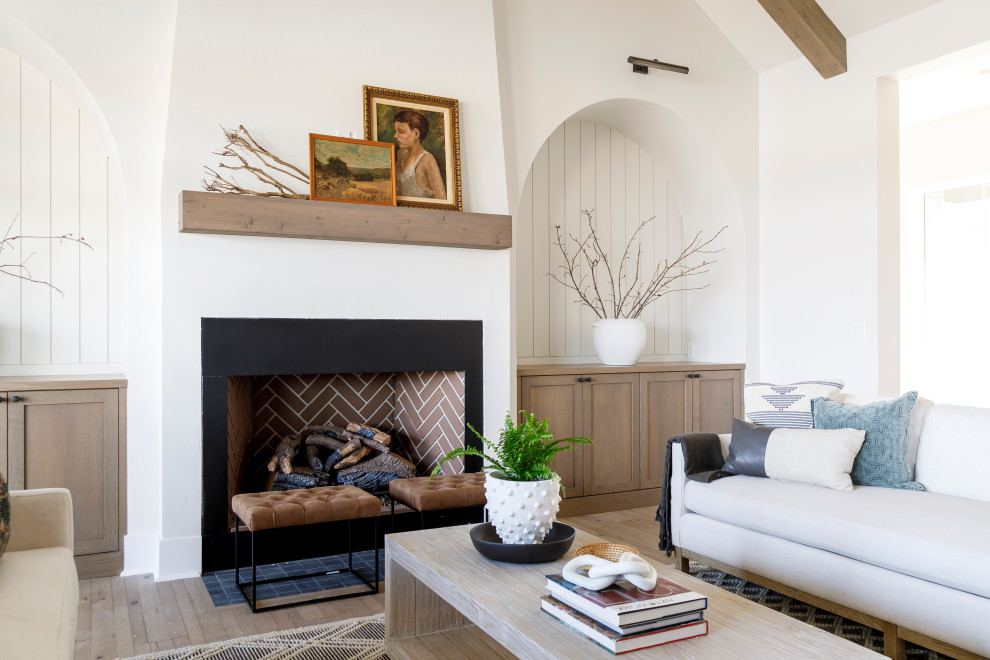 Mittelgroßes Landhausstil Wohnzimmer mit weißer Wandfarbe, braunem Holzboden, Kamin, verputzter Kaminumrandung, gewölbter Decke und Holzdielenwänden in Boise