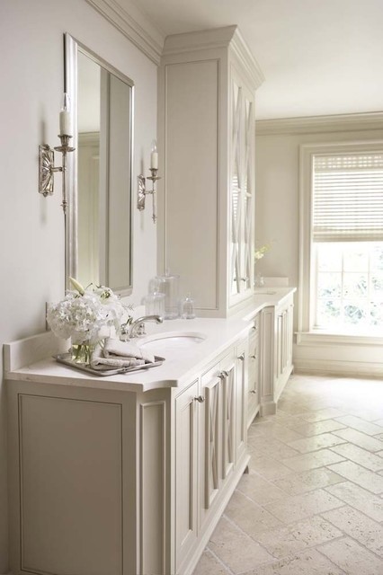This is an example of a large traditional master bathroom in Chicago with shaker cabinets, white cabinets, white walls, limestone floors, an undermount sink and solid surface benchtops.