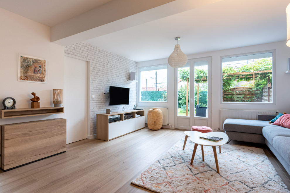 This is an example of a large contemporary living room in Paris with white walls, ceramic floors, a wall-mounted tv, brown floor and wallpaper.