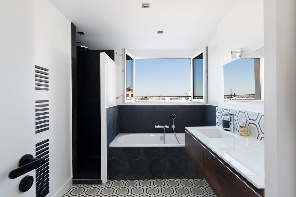 Contemporary master bathroom in Bordeaux with flat-panel cabinets, dark wood cabinets, an alcove tub, black tile, multi-coloured tile, white walls, an undermount sink, multi-coloured floor and white benchtops.