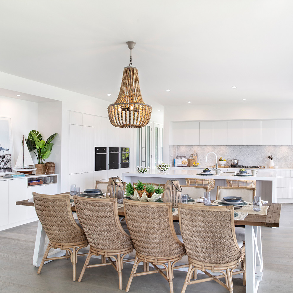 Beach style kitchen/dining combo in Sydney with white walls, medium hardwood floors, no fireplace and brown floor.