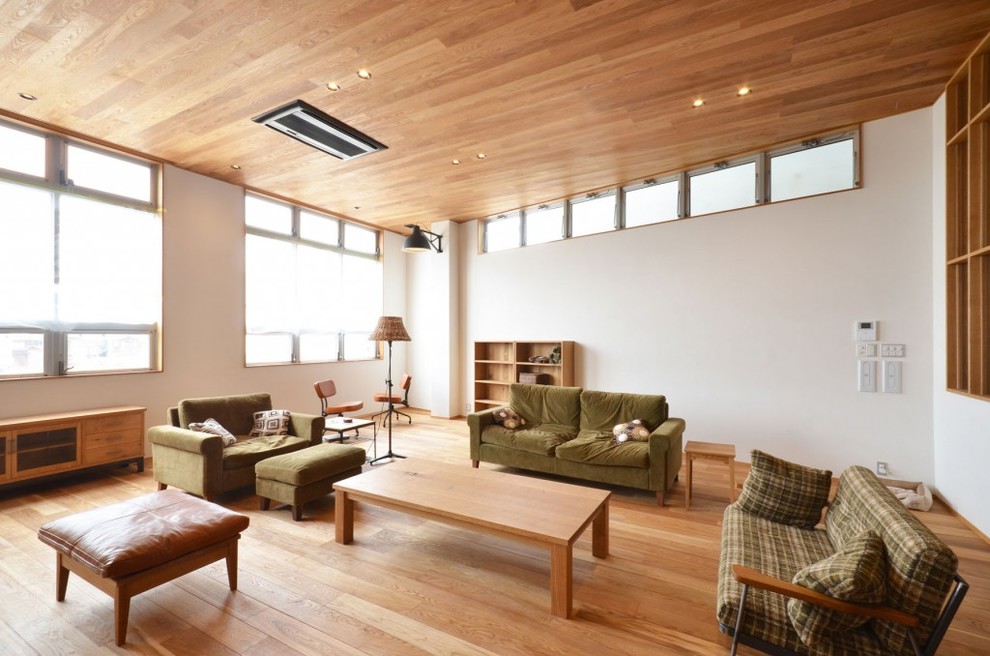 Asian living room in Tokyo with white walls and medium hardwood floors.