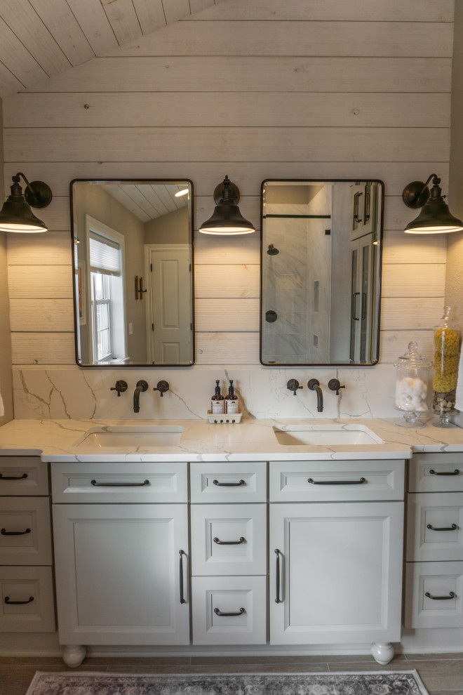 Photo of a large farmhouse ensuite bathroom in Milwaukee with flat-panel cabinets, grey cabinets, a corner shower, a one-piece toilet, black and white tiles, wood-effect tiles, grey walls, a submerged sink, quartz worktops, beige floors, a hinged door, beige worktops, a wall niche, double sinks, a built in vanity unit, a vaulted ceiling and tongue and groove walls.