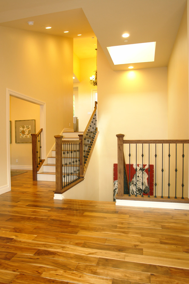 This is an example of a large arts and crafts wood u-shaped staircase in San Francisco with painted wood risers.