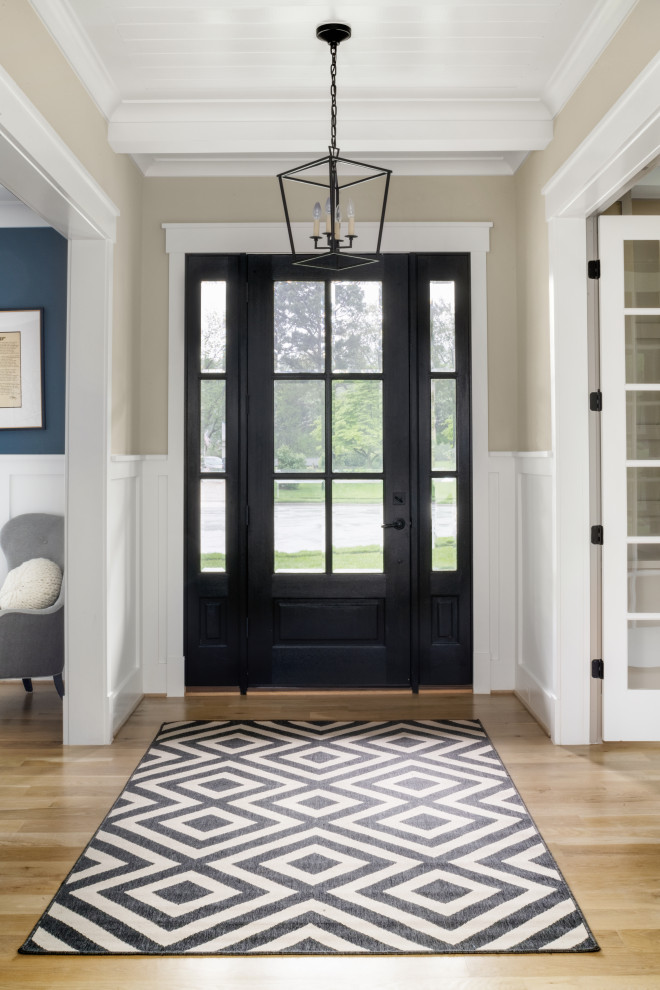 Photo of a classic entrance in DC Metro with light hardwood flooring, a single front door, a black front door, a timber clad ceiling and wainscoting.