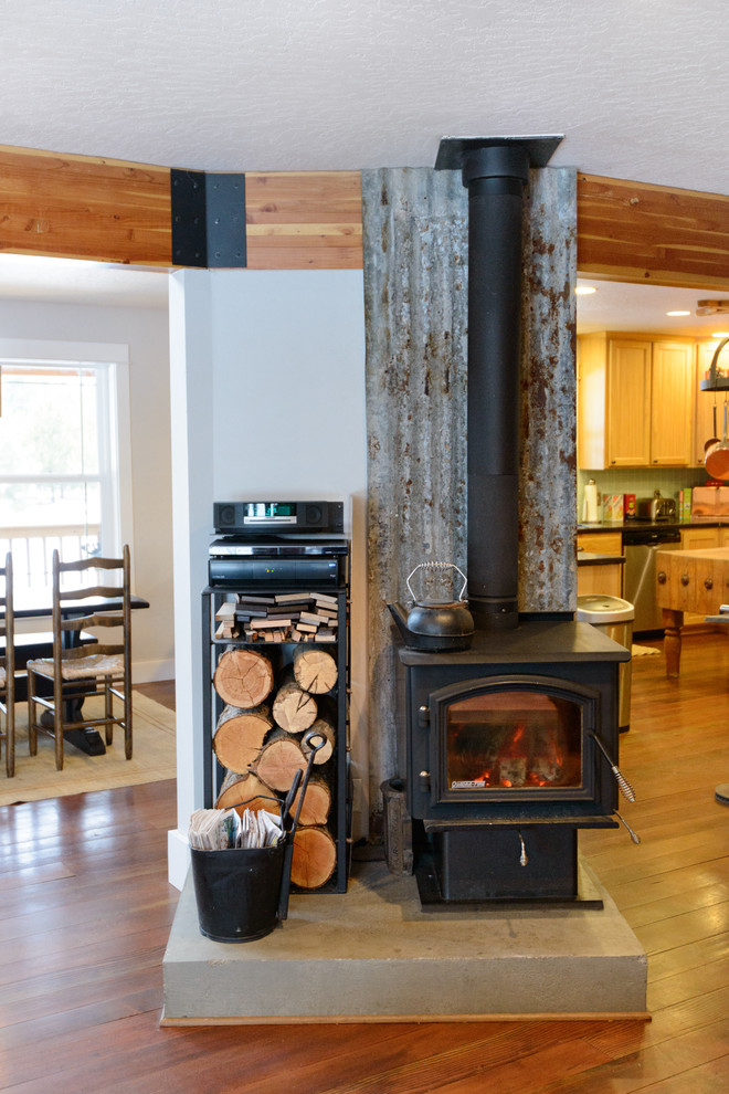 This is an example of an eclectic open concept living room in Seattle with medium hardwood floors and a wood stove.