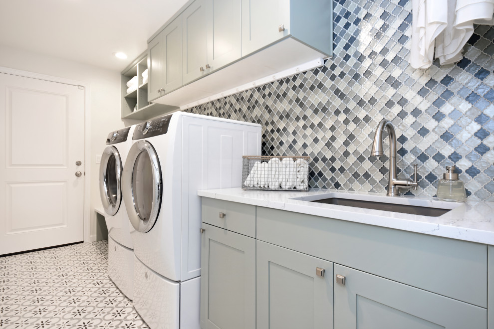 Inspiration for a medium sized contemporary single-wall utility room in Seattle with a submerged sink, shaker cabinets, green cabinets, engineered stone countertops, multi-coloured splashback, glass tiled splashback, white walls, ceramic flooring, a side by side washer and dryer, white floors and white worktops.