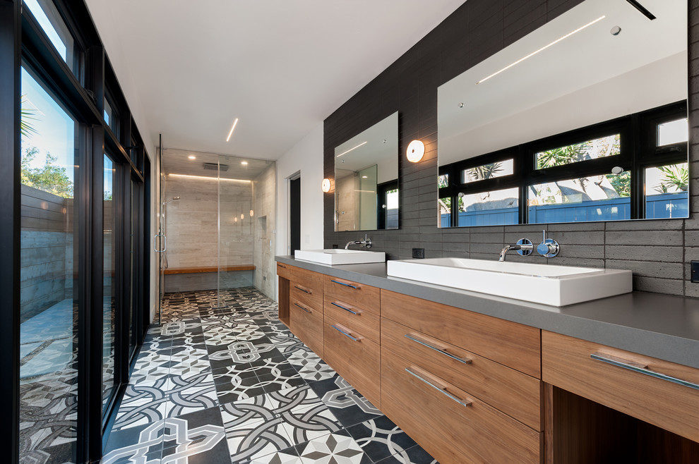 Inspiration for a large contemporary master bathroom in San Diego with a vessel sink, flat-panel cabinets, medium wood cabinets, a curbless shower, gray tile, white walls, stone tile, ceramic floors, solid surface benchtops and grey benchtops.