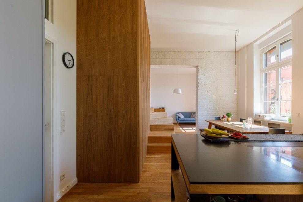 Geräumiges, Repräsentatives, Offenes Modernes Wohnzimmer mit weißer Wandfarbe, hellem Holzboden und Ziegelwänden in Berlin