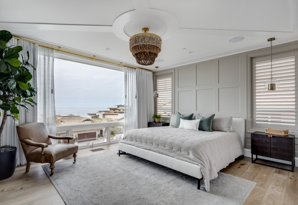 Maritimes Hauptschlafzimmer mit grauer Wandfarbe, hellem Holzboden und Wandpaneelen in Orange County