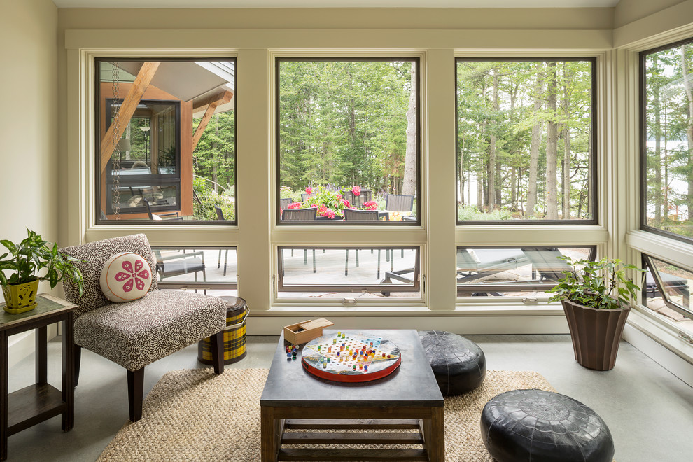 This is an example of a transitional sunroom in Portland Maine with concrete floors.
