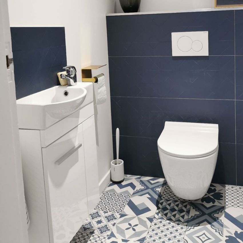 Ejemplo de aseo contemporáneo pequeño con sanitario de pared, paredes blancas, suelo de azulejos de cemento y suelo azul