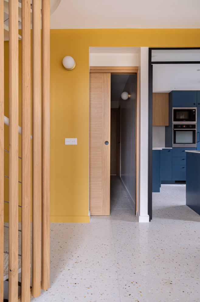 Источник вдохновения для домашнего уюта: фойе среднего размера в современном стиле с желтыми стенами, полом из терраццо и деревянными стенами