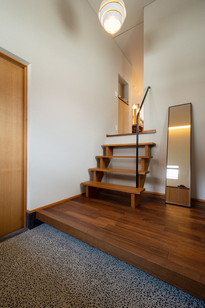 Foto di un corridoio minimalista di medie dimensioni con pareti bianche, parquet scuro, soffitto in carta da parati, carta da parati, una porta singola e una porta in legno bruno