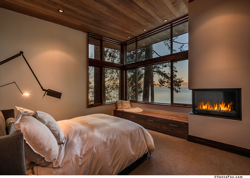 Design ideas for a large contemporary guest bedroom in Sacramento with beige walls, carpet, a ribbon fireplace and a metal fireplace surround.