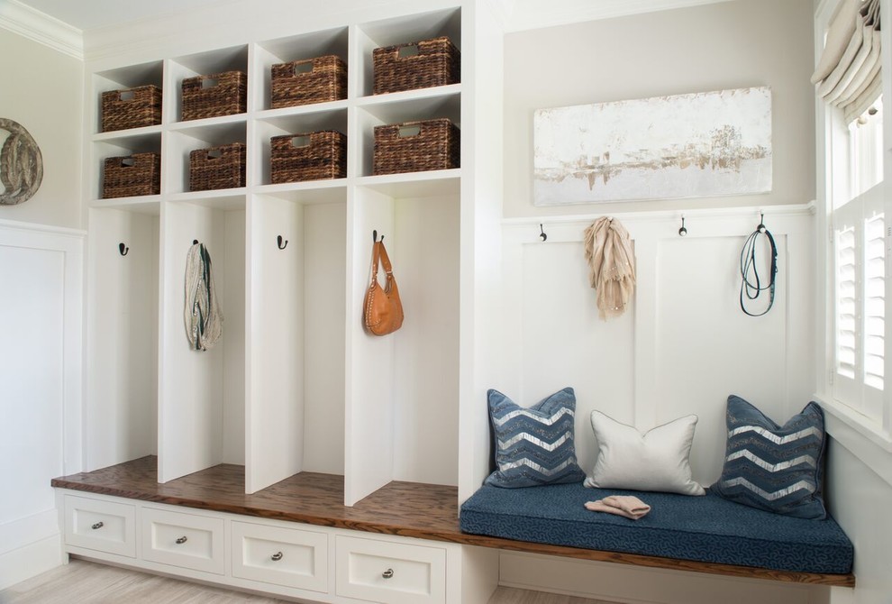 Example of a mid-sized transitional light wood floor and beige floor mudroom design in DC Metro with white walls