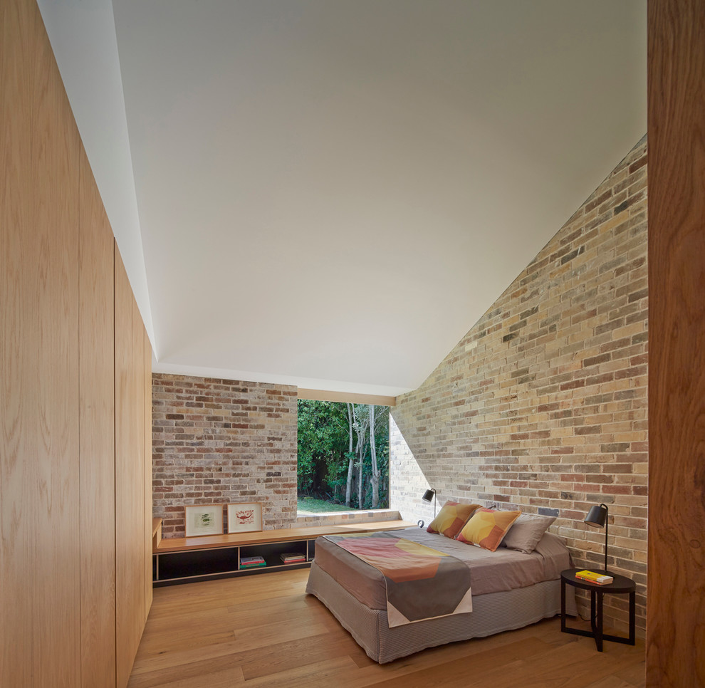 Mid-sized contemporary master bedroom in Sydney with light hardwood floors.