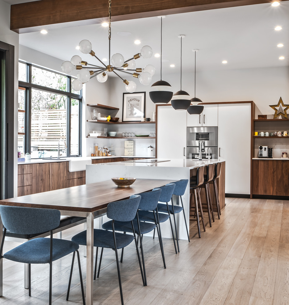 Design ideas for a contemporary l-shaped eat-in kitchen in Seattle with an integrated sink, flat-panel cabinets, dark wood cabinets, white splashback, stainless steel appliances, light hardwood floors, with island, beige floor and white benchtop.