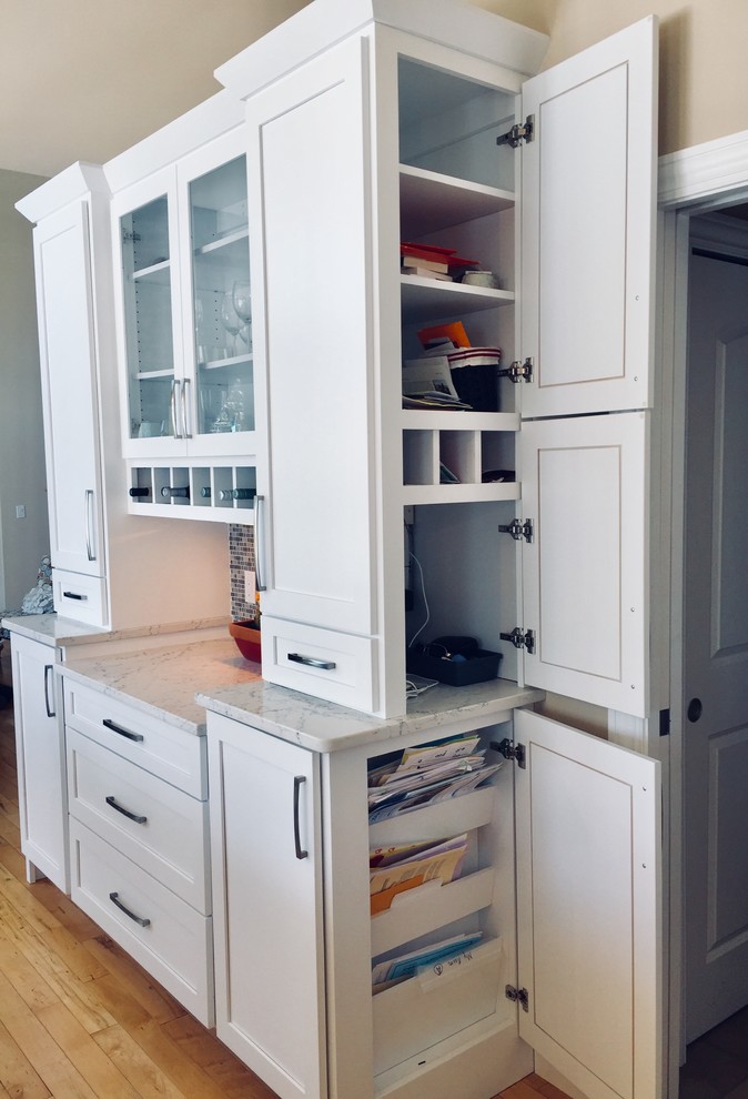 Inspiration for a mid-sized transitional light wood floor kitchen remodel with shaker cabinets, quartz countertops, gray backsplash, glass tile backsplash and an island