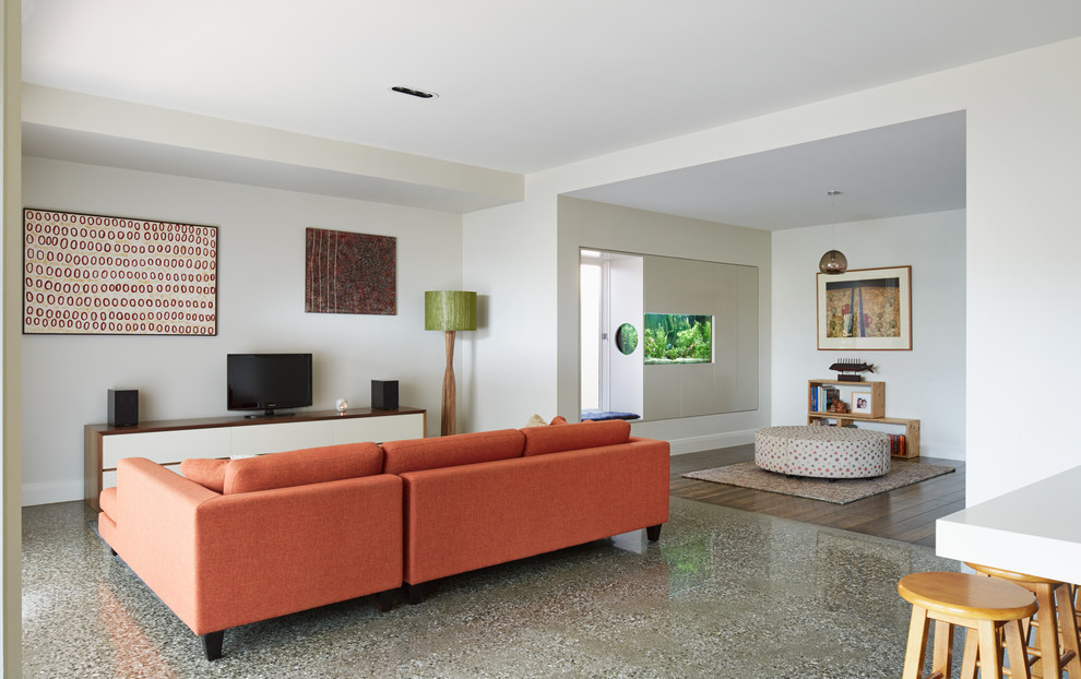 Photo of a large contemporary open concept living room in Melbourne with white walls, concrete floors, a freestanding tv and grey floor.
