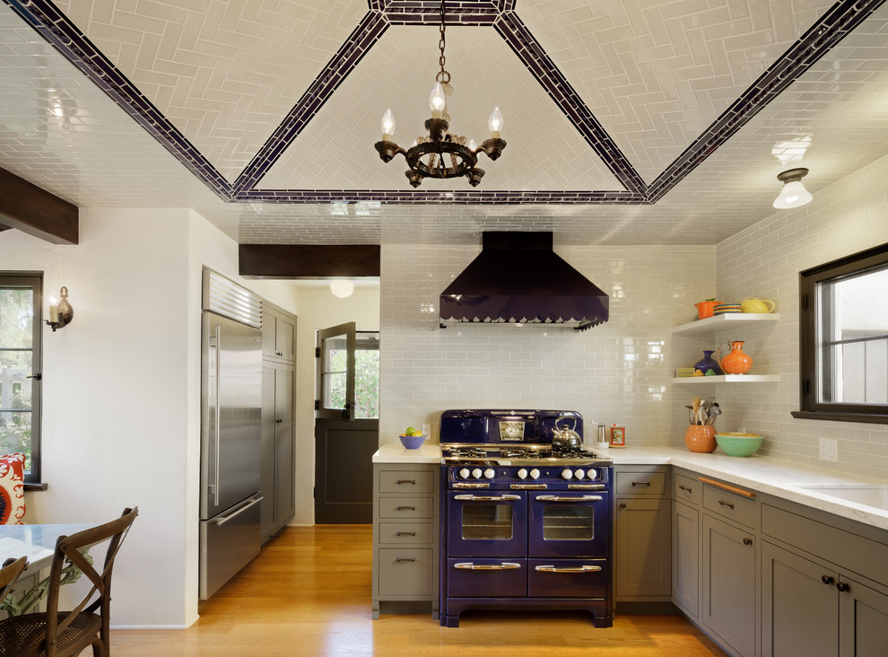 Mediterranean u-shaped eat-in kitchen in Los Angeles with a single-bowl sink, flat-panel cabinets, grey cabinets, marble benchtops, white splashback, subway tile splashback and coloured appliances.