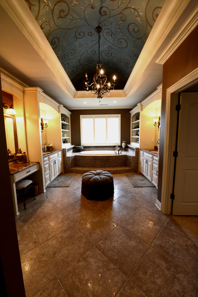 This is an example of an expansive arts and crafts master bathroom in Indianapolis with an undermount sink, raised-panel cabinets, white cabinets, granite benchtops, a drop-in tub, an alcove shower, a one-piece toilet, beige tile, porcelain tile, brown walls and porcelain floors.