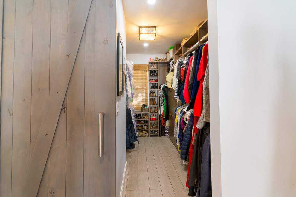 Eclectic walk-in wardrobe in Orange County with light wood cabinets and ceramic floors.