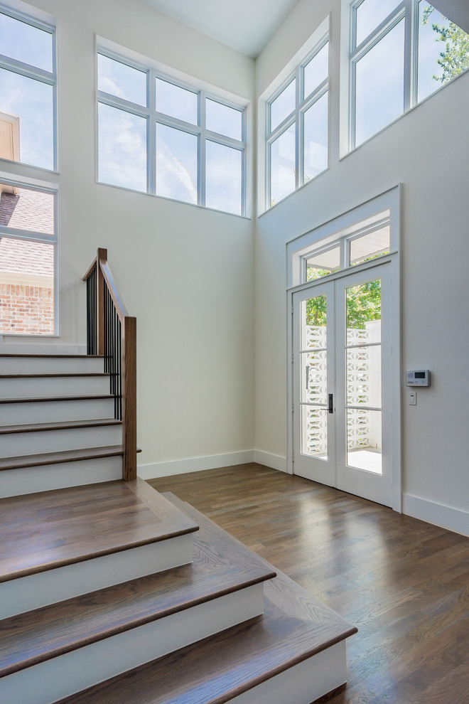 Example of a large transitional light wood floor foyer design in Dallas with white walls and a white front door