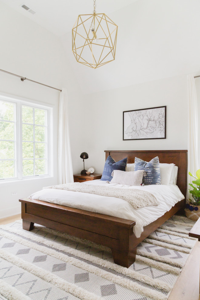 Photo of a scandinavian master bedroom in Chicago with white walls and vaulted.