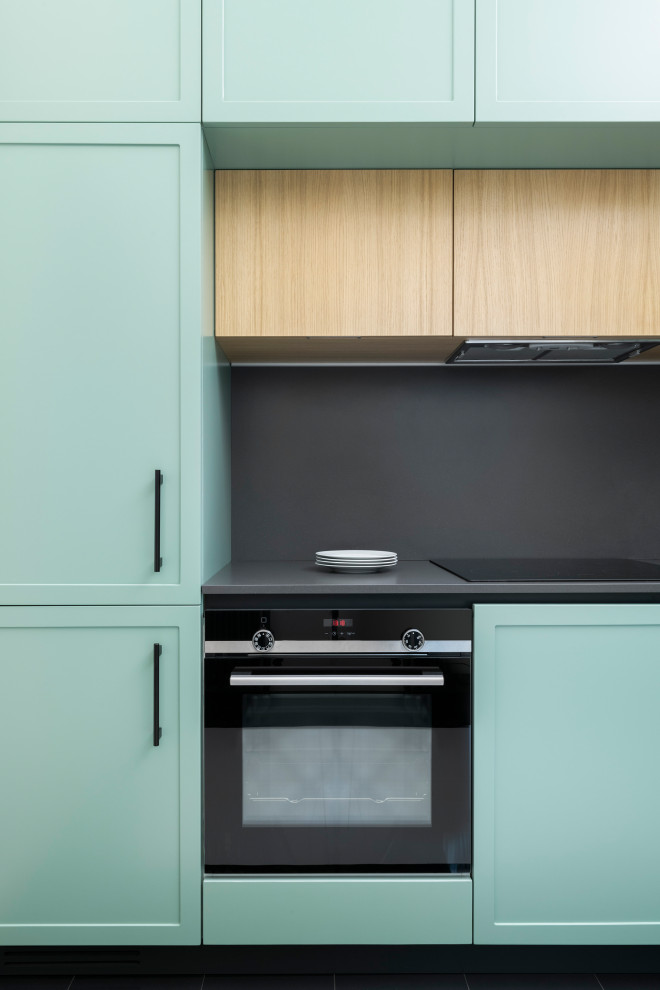 This is an example of a mid-sized scandinavian l-shaped separate kitchen in Milan with an undermount sink, recessed-panel cabinets, green cabinets, quartz benchtops, grey splashback, engineered quartz splashback, stainless steel appliances, porcelain floors, no island, multi-coloured floor and grey benchtop.