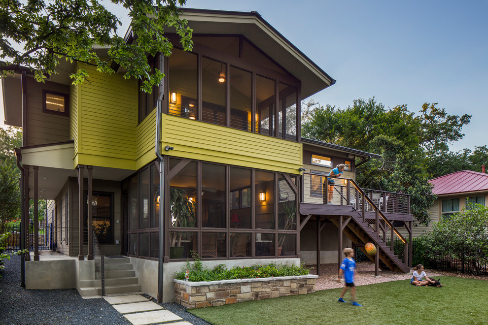 Photo of a traditional split-level green house exterior in Austin with concrete fiberboard siding and a gable roof.