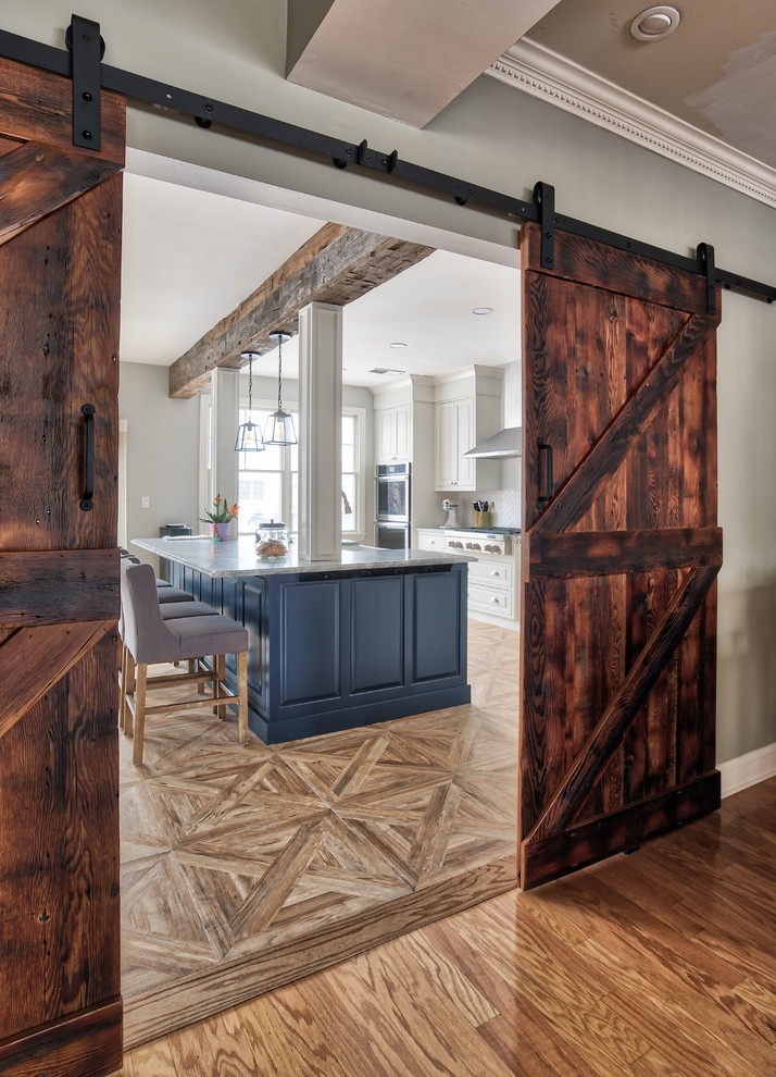 Large cottage l-shaped ceramic tile and brown floor eat-in kitchen photo in New York with a farmhouse sink, beaded inset cabinets, blue cabinets, marble countertops, white backsplash, subway tile backsplash, stainless steel appliances and an island