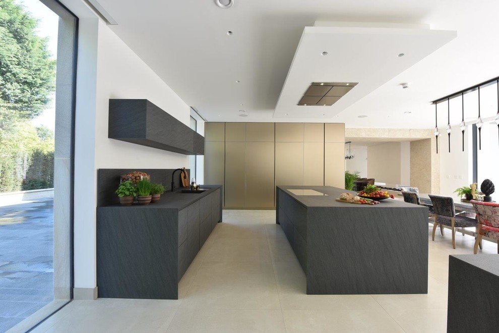 Design ideas for a large contemporary kitchen in Cheshire with with island, a drop-in sink, flat-panel cabinets, grey cabinets, granite benchtops, grey splashback, stone slab splashback, coloured appliances, porcelain floors, beige floor and grey benchtop.