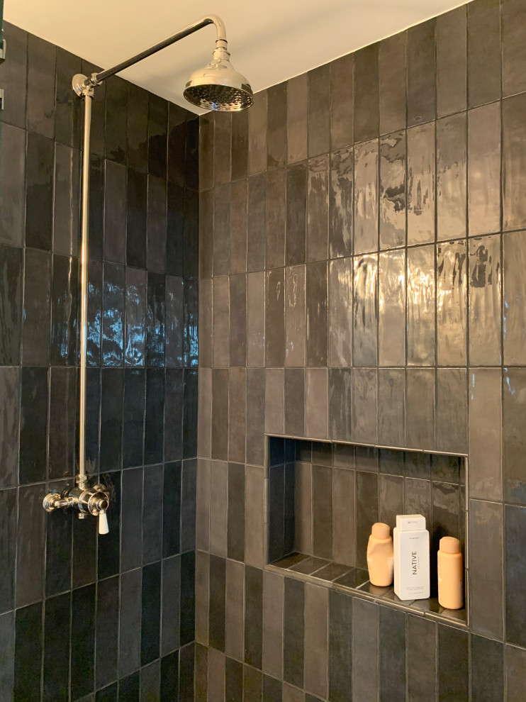 Photo of a small midcentury 3/4 bathroom in Los Angeles with shaker cabinets, grey cabinets, a corner tub, black tile, white walls, cement tiles, an undermount sink, granite benchtops, black floor, a hinged shower door, white benchtops, a niche, a single vanity and a freestanding vanity.
