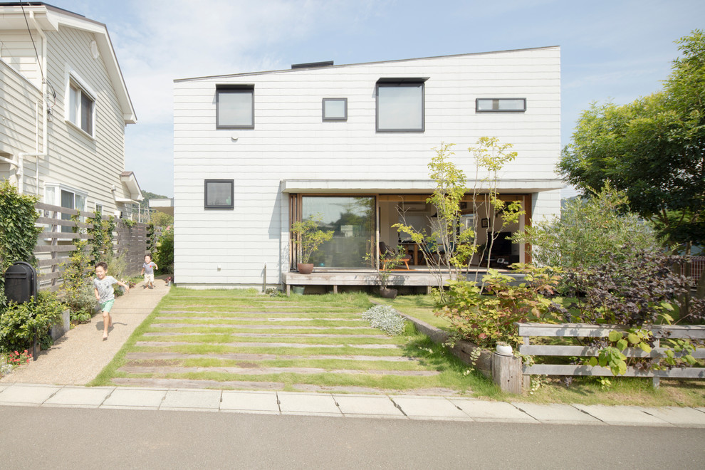 Photo of a contemporary two-storey white exterior in Tokyo Suburbs with a shed roof.