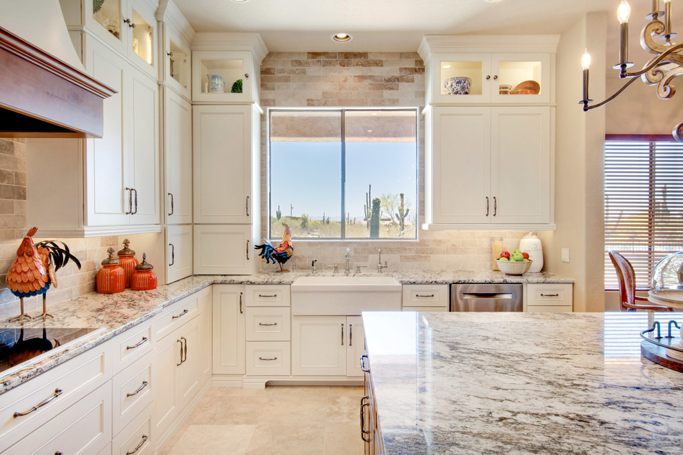 Inspiration for a large transitional u-shaped travertine floor and beige floor open concept kitchen remodel in Phoenix with a farmhouse sink, recessed-panel cabinets, white cabinets, granite countertops, gray backsplash, porcelain backsplash, stainless steel appliances, an island and multicolored countertops