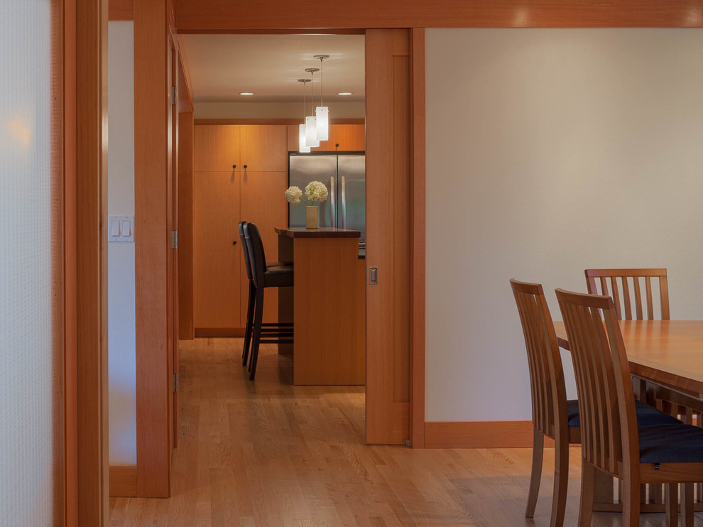 Great room - mid-sized transitional light wood floor great room idea in Seattle with white walls, a standard fireplace and a tile fireplace