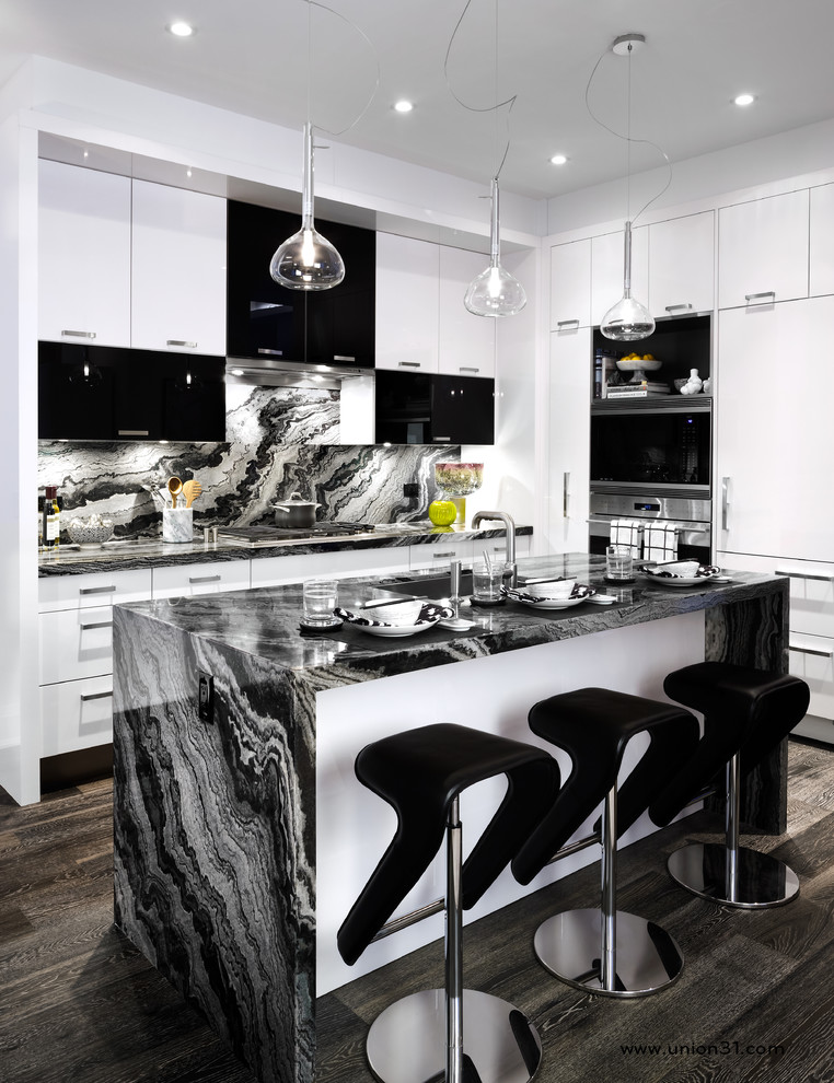 This is an example of a mid-sized contemporary l-shaped open plan kitchen in Toronto with an undermount sink, glass-front cabinets, white cabinets, granite benchtops, black splashback, stone slab splashback, stainless steel appliances, medium hardwood floors and with island.