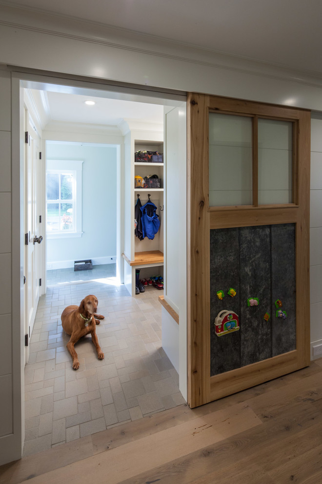Traditional mudroom in Boston with white walls and medium hardwood floors.