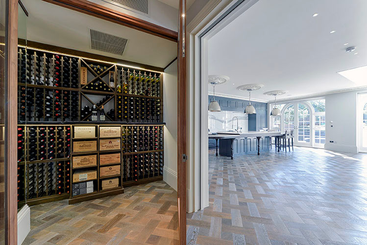 Inspiration for a large contemporary wine cellar in London with medium hardwood floors and storage racks.
