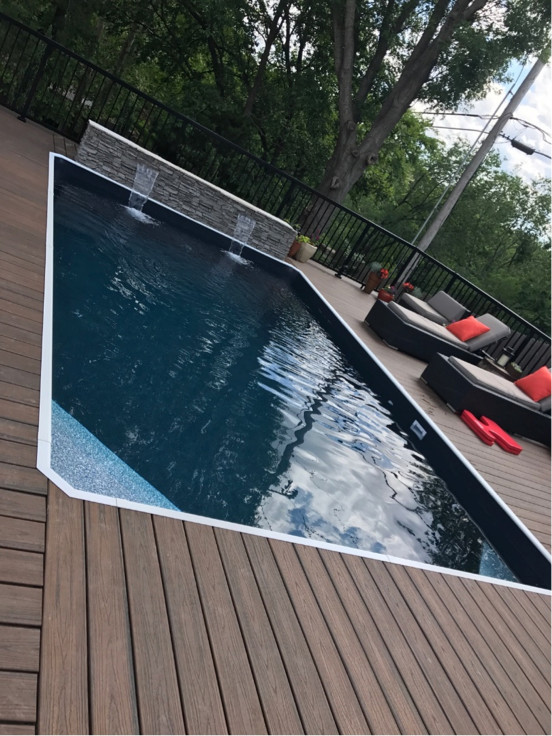 Inspiration for a mid-sized modern backyard rectangular pool remodel in Detroit with decking